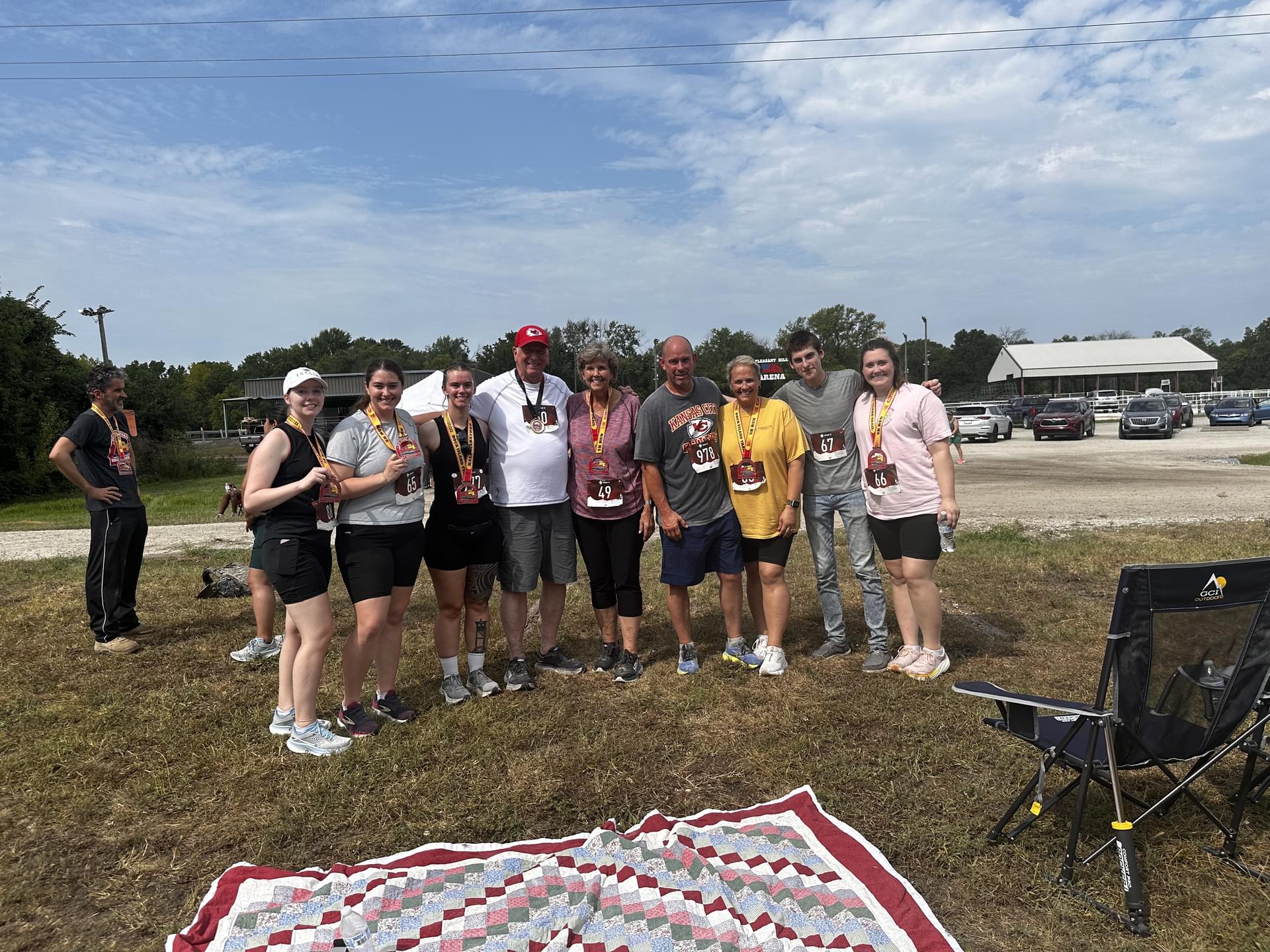 post-race photo of Annie with family and train medals